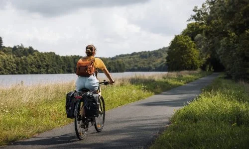 Cycliste avec sacoches sur une voie verte au bord de l'eau, Boucle de la Moselle